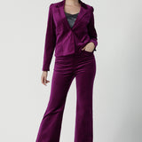 Front view of a size 10 woman wears the Sasha jacket in Magenta velveteen. A cocktail pant suit that is made in Australia for size 8 - 24. A matching suit set in velveteen. Event wear for petite to plus size women. Styled back with the Jonas pant.