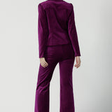 Back view of a size 10 woman wears the Sasha jacket in Magenta velveteen. A cocktail pant suit that is made in Australia for size 8 - 24. A matching suit set in velveteen. Event wear for petite to plus size women. Styled back with the Jonas pant. 