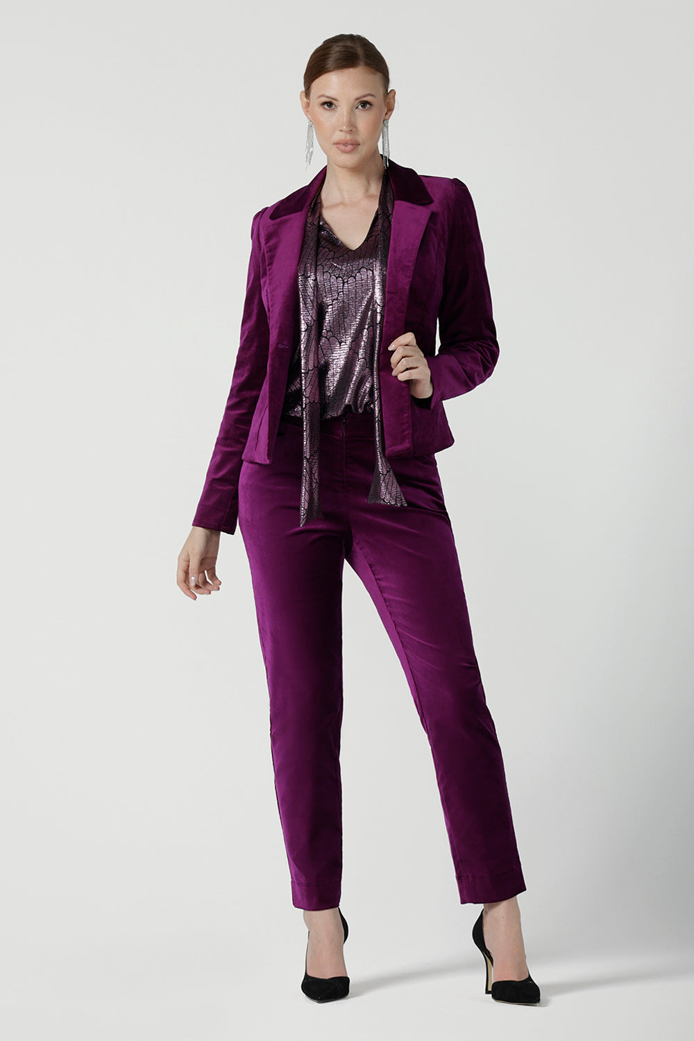 Front view of a size 10 woman wears the Sasha jacket in Magenta velveteen. A cocktail pant suit that is made in Australia for size 8 - 24. A matching suit set in velveteen. Event wear for petite to plus size women. Styled back with the Jonas pant.