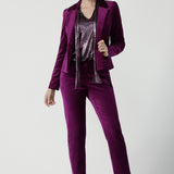 Front view of a size 10 woman wears the Sasha jacket in Magenta velveteen. A cocktail pant suit that is made in Australia for size 8 - 24. A matching suit set in velveteen. Event wear for petite to plus size women. Styled back with the Jonas pant.