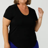 A good plus size top, this round neck, short sleeve top in black bamboo jersey is comfortable for work and casual wear. Worn by a curvy, size 18 woman, this top is made in Australia by ladies clothing brand, Leina & Fleur. Shop black tops for women online in sizes 8 to 24 in L&F's online fashion boutique.