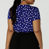 Back view of a size 16 curvy woman wears a scoop neckline top on a polka dot print with a cobalt base. Made in Australia for women size 8 to 24.