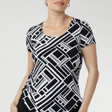 Designed with a flattering fitted silhouette, this versatile top features a classic round neckline, short sleeves, and a curved shirttail hemline that adds a modern touch to any outfit. Available in sizes 8-24