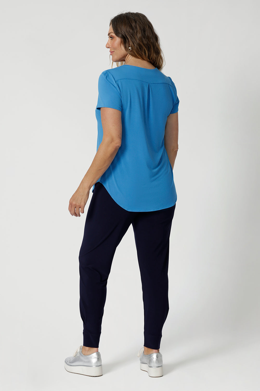 Size 12 model wears short sleeved summer top featuring relaxed scoop neckline, shirt-tail hemline adding a modern touch, creating a slightly longer back for a flattering shape. Combining effortless style with sustainability. This bamboo top is perfect for easygoing days in the sun.