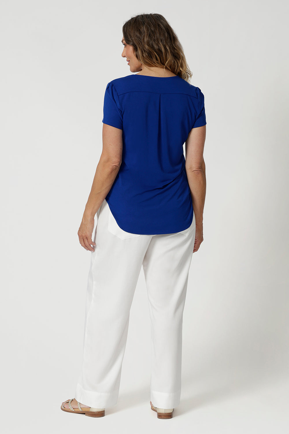 Over 40's woman wears casual short sleeved top made from bamboo fabric, perfect for those who prioritise eco-friendly options without sacrificing style or comfort. Travel ready top features a shirttail hemline & scoop neckline providing chic features within a casual top