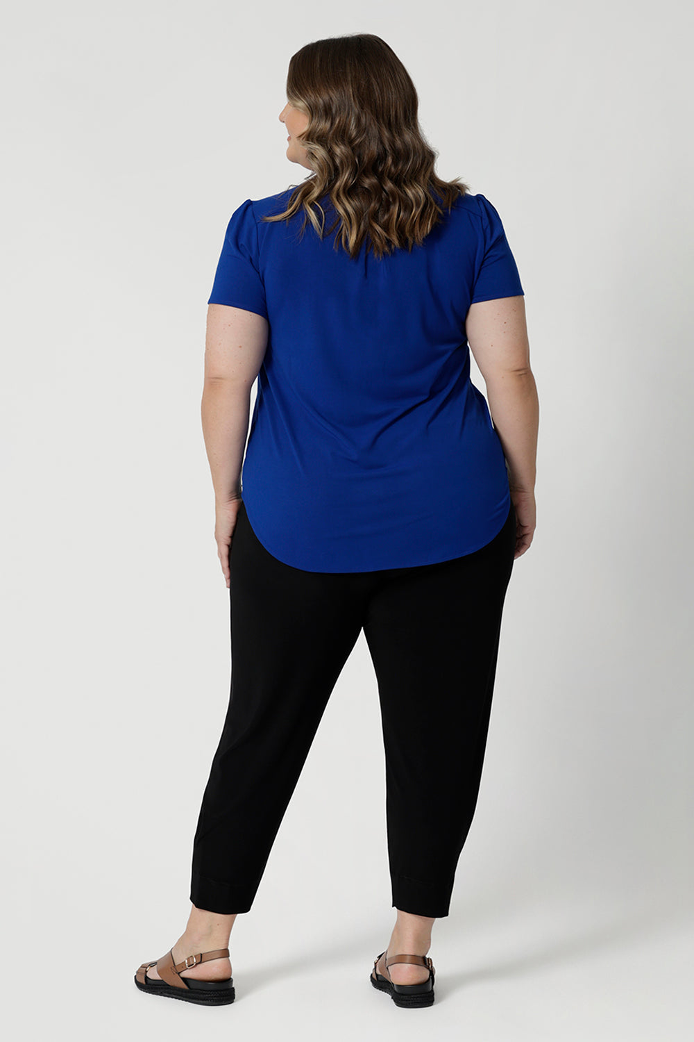 Plus size model styles bold top with travel comfortable pants and a brown sandal doe a casual yet stylish everyday look. Add this stylish yet versatile piece to your wardrobe. Shop now in sizes 8-24.