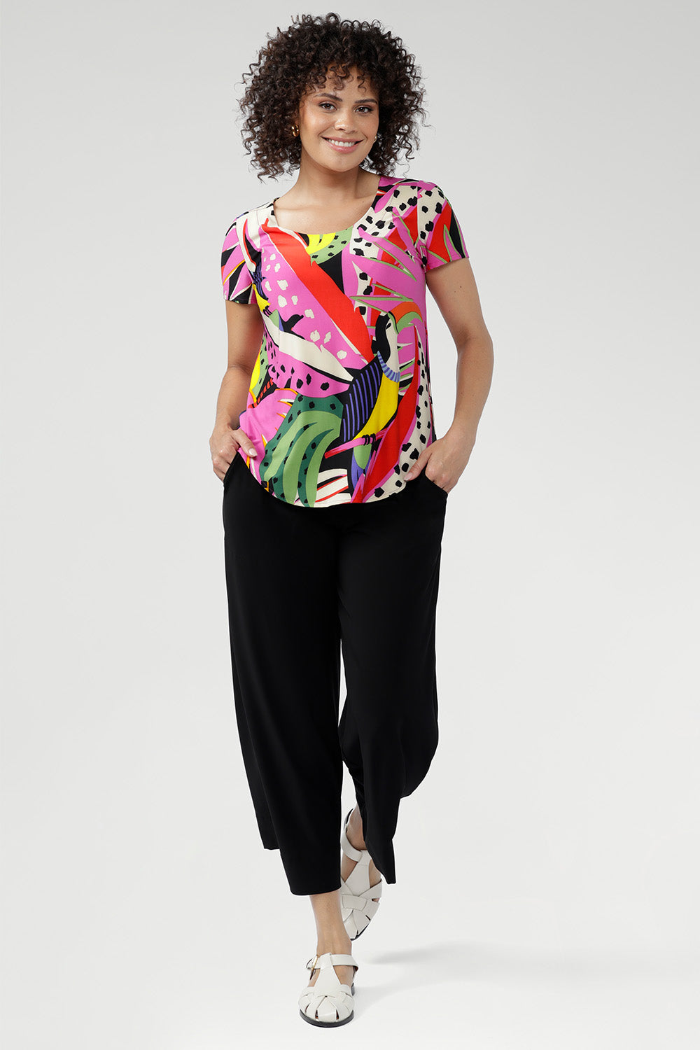 The Tucan print blends abstract strokes of pinks, reds, greens, and black on a warm cream base, creating a vibrant, artful pop that enlivens any outfit. Wear with tailored pants and or summer skirts.