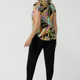 Back view of a size 10 woman wears the Sawyer Top in jersey with Zanzibar print. A multi coloured print with a black base and beautiful bright colours. Made in Australia for women size 8-24. Styled back with the Indi Pant in Black.  