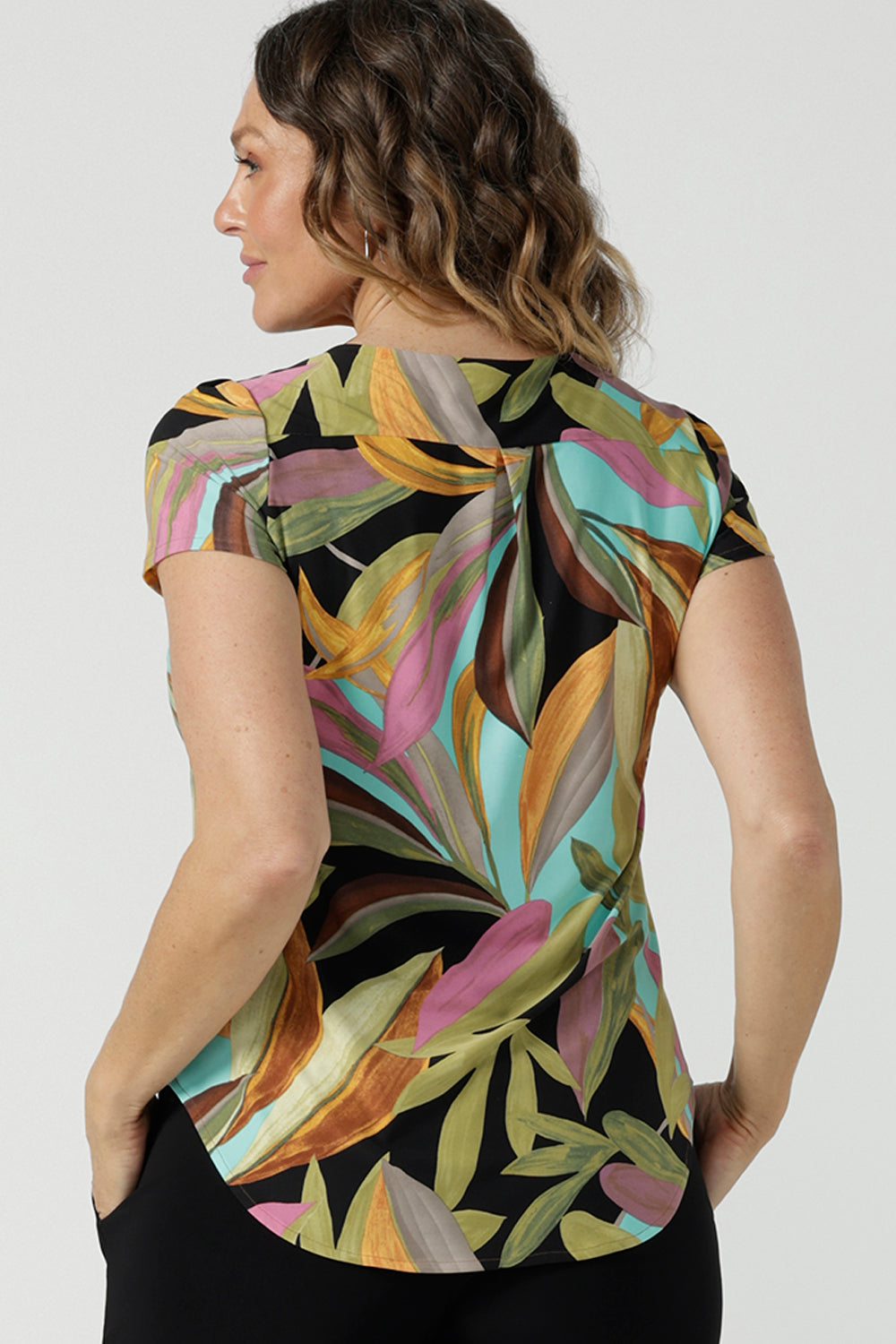 Back view of a size 10 woman wears the Sawyer Top in jersey with Zanzibar print. A multi coloured print with a black base and beautiful bright colours. Made in Australia for women size 8-24. 