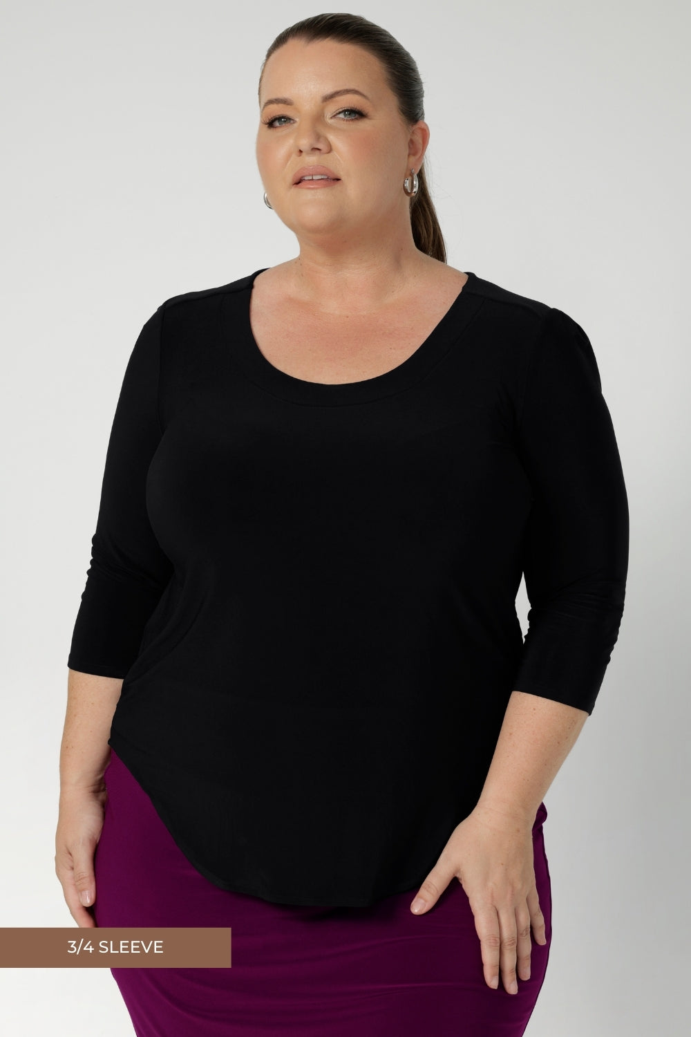 Versatile black workwear top features scoop neck, 3/4 sleeves, and shirt tail hemline. Perfect blend of style and practicality for the working woman.  Designed to effortlessly transition between smart and casual occasion.