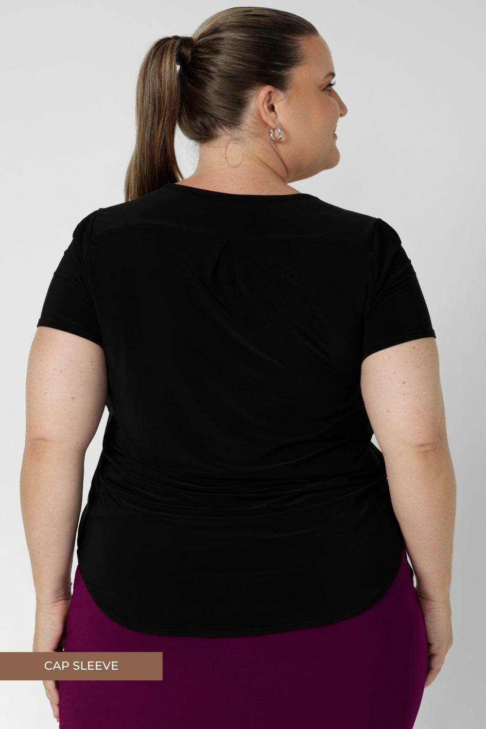 Choose a sleeve length style, one of 3. It’s offered in three classic colourways, allowing for maximum versatility and pairing with a variety of other wardrobe pieces. Plus size woman wears short sleeved black workwear top.