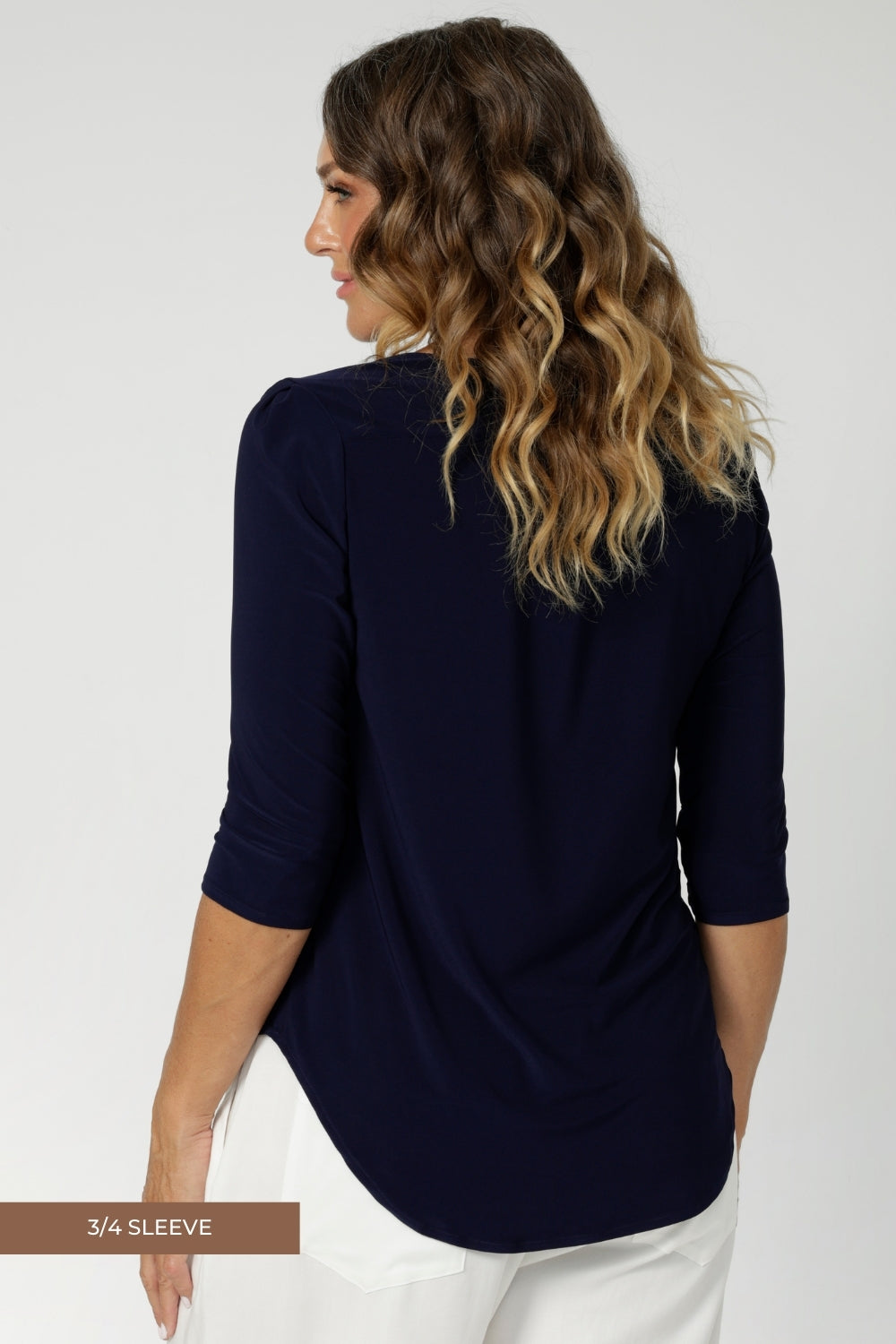 3/4 sleeved top odeal for layering, works brilliantly under Leina & Fleur suiting jackets and cardigans. Adding a refined, polished look to your outfit. Size 12 model wears navy workwear top with white tailored pants. 