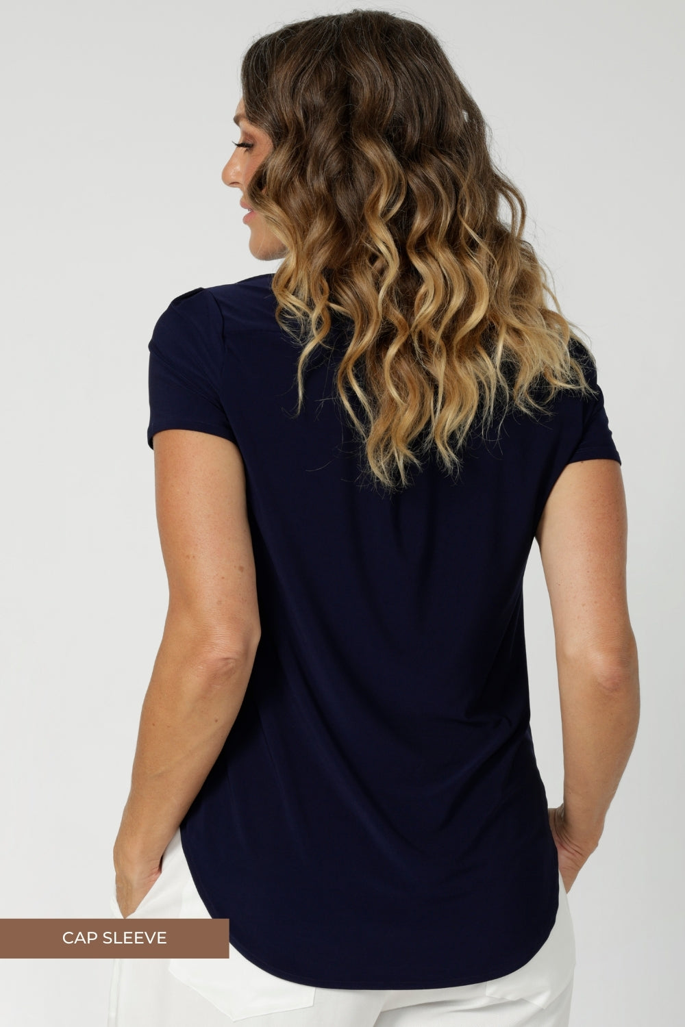 Back view image of womans workwear top avaialable for pre order. Choose from three sleeve options—cap sleeve, elbow sleeve, or 3/4 length sleeve—you can choose the one that best suits your personal style or the season. In sizes 8-24.