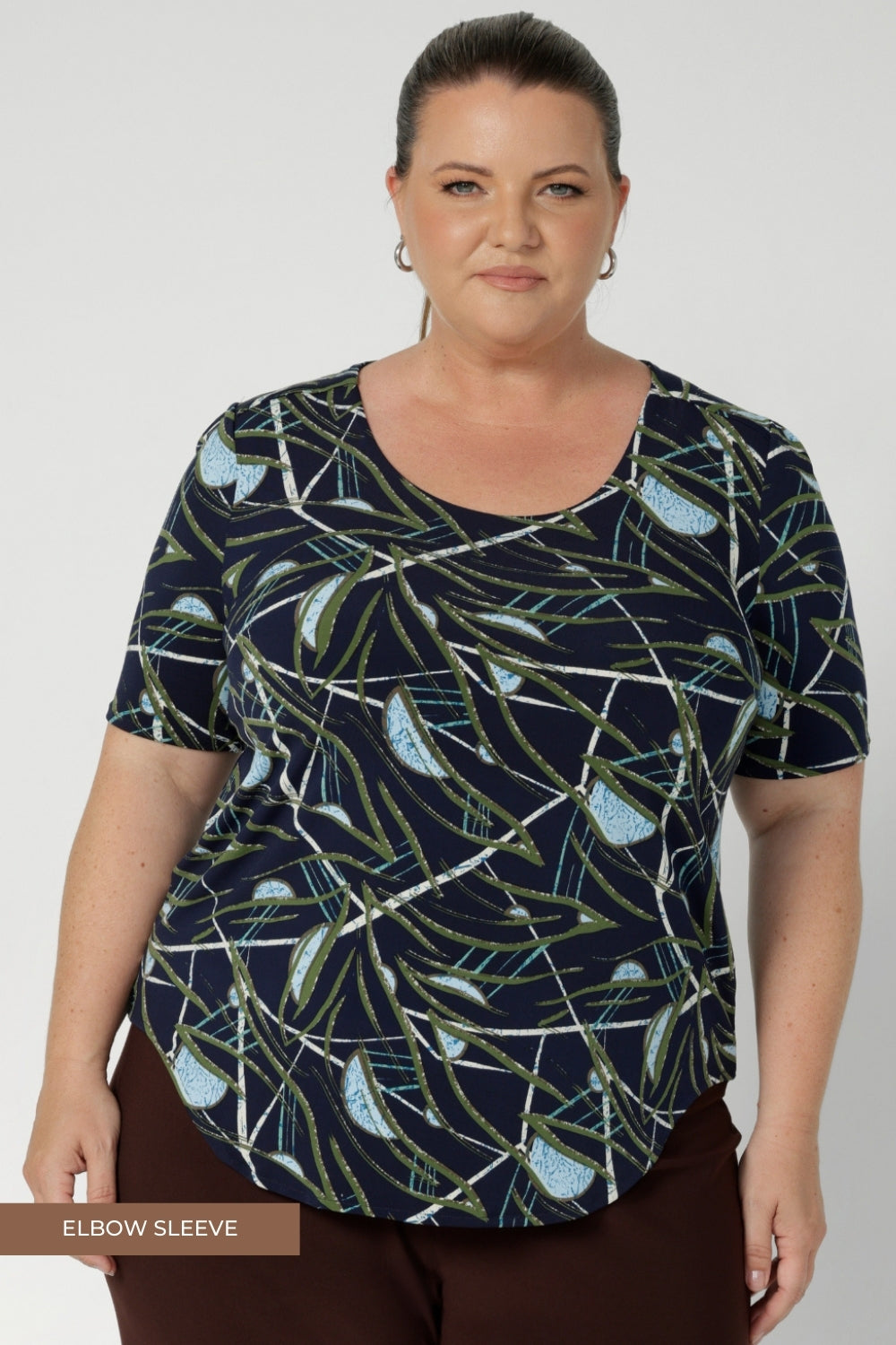 Size 18 woman wears simple yet elegant scoop neckline design, which offers a flattering fit for a variety of body shapes, making it a wardrobe staple. Ideal for layering, it works brilliantly under Leina & Fleur suiting jackets and cardigans, adding a refined, polished look to your outfit. Available for pre order in sizes 8-24.