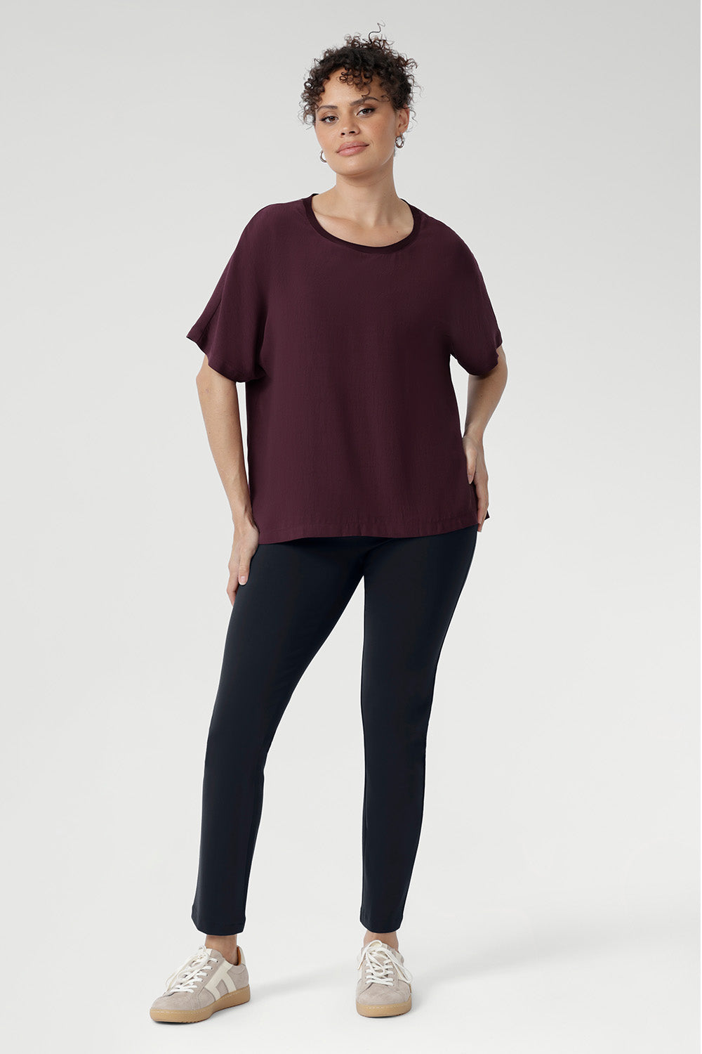 Effortlessly stylish and endlessly versatile, the Scout Tee in Plum is the perfect pairing for your everyday wardrobe. Worn here by a size 10 woman with charcoal-coloured pants, this look captures relaxed elegance with a modern edge.