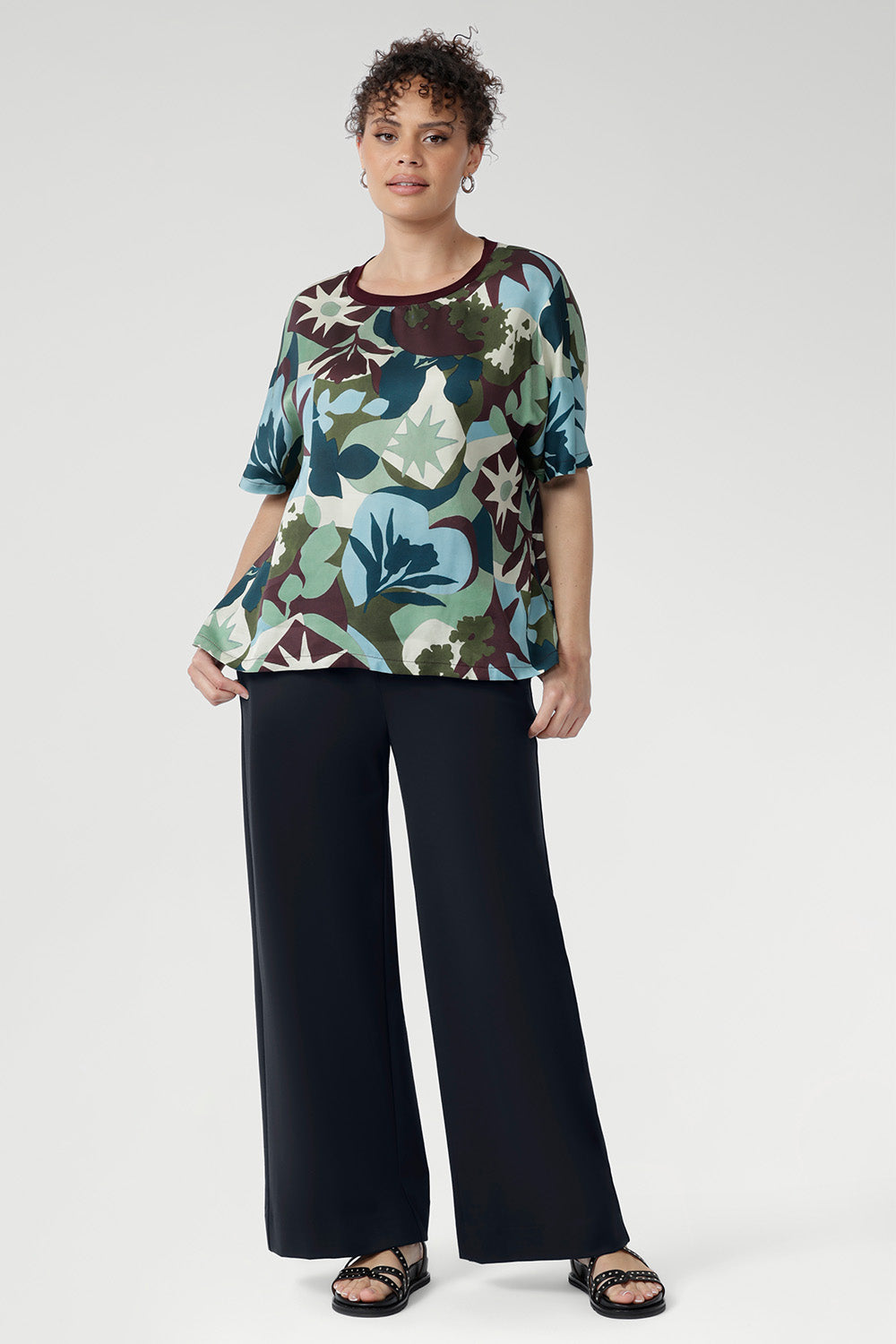 The relaxed fit, grown-on sleeves, and softly bound round neckline offer a clean, modern silhouette that flatters without trying too hard. A striking abstract print in green, blue, and plum tones brings a touch of bold personality, while the straight hem makes styling simple, whether worn loose or tucked in.