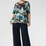 The relaxed fit, grown-on sleeves, and softly bound round neckline offer a clean, modern silhouette that flatters without trying too hard. A striking abstract print in green, blue, and plum tones brings a touch of bold personality, while the straight hem makes styling simple, whether worn loose or tucked in.