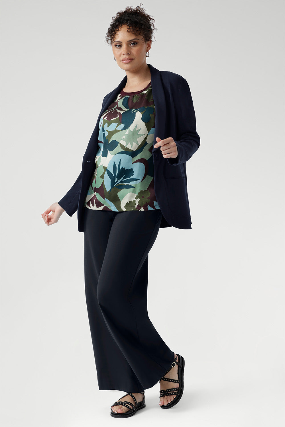 A striking abstract print in green, blue, and plum tones brings a touch of bold personality, while the straight hem makes styling simple whether worn loose or tucked in. Size 10 model wears the relaxed fit tee with navy blazer and black sandals.
