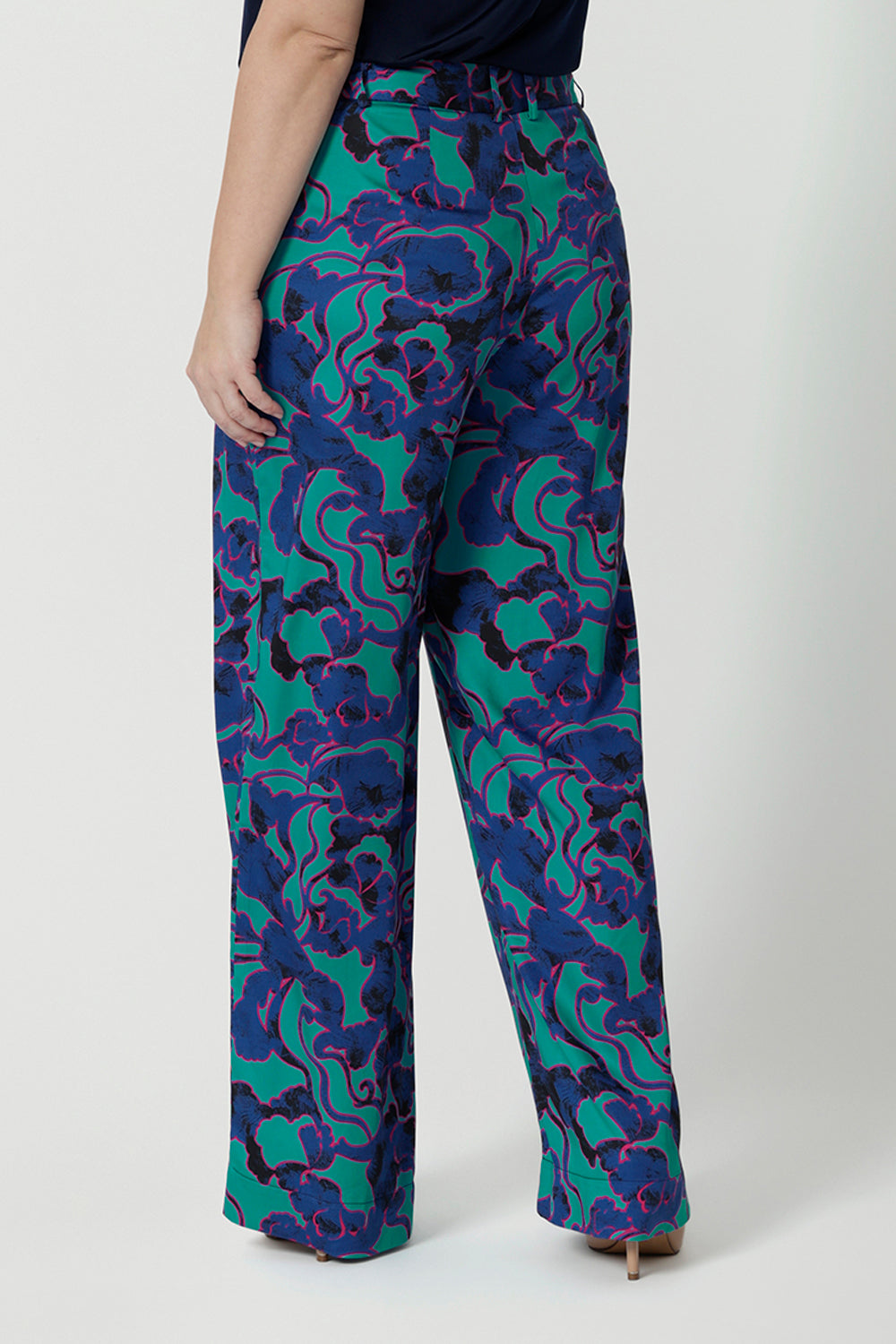 Back view of good pants for petite height women, these wide leg printed pants are part of a coord set. The abstract design of the set displays navy, pink and aqua blue colours. This Australian made shirt and pant set is made from easy care, satin rayon fabric that is breathable and comfortable. Leina and Fleur is a women’s clothing company that actively stocks plus sizes & petite sizes ranging from 8 to 24.