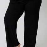Close up of a size 18 woman wearing straight, wide leg black bamboo lounge pants. Thermo-regulating and breathable this is a great pyjama set for night sweats and hot flushes. Shop plus size lounge and sleepwear online at L&F Australia.