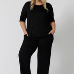 Showing a sleepwear slouchy tee top, a size 18 woman wears a plus size lounge top in black bamboo with straight leg black bamboo lounge pants. A 3/4 top with high neck, this lounge top is breathable and thermo-regulating so it make good pyjamas for night sweats and hot flushes. Shop lounge and sleepwear in sizes 8 to24 online at L&F Australia.