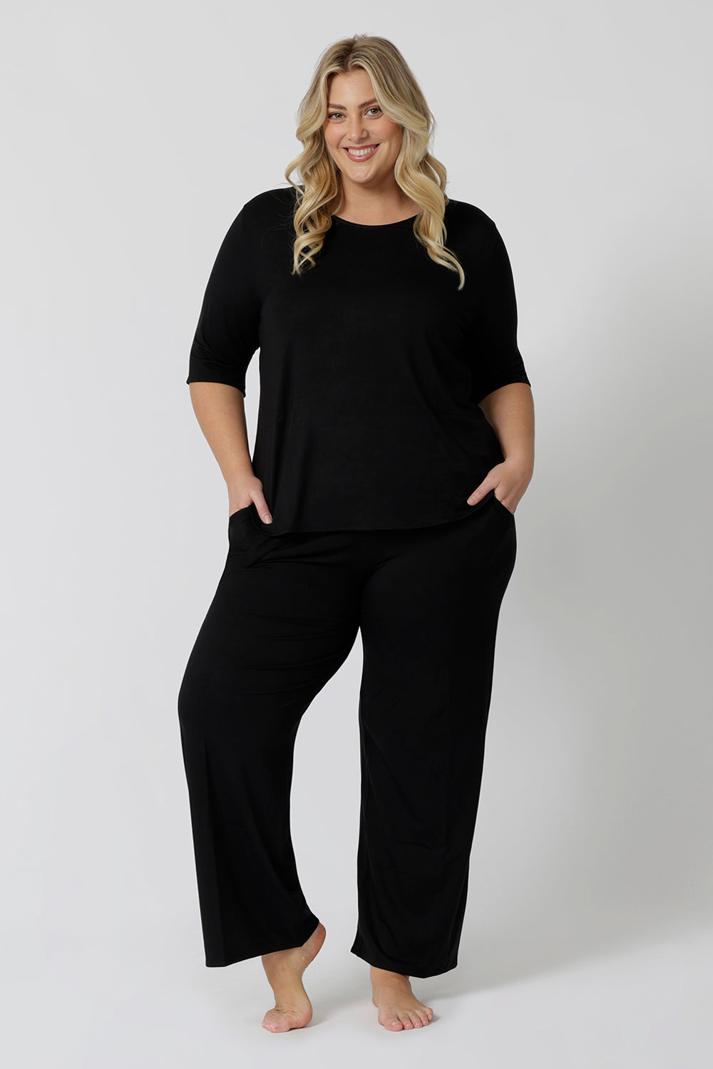 Showing a sleepwear slouchy tee top, a size 18 woman wears a plus size lounge top in black bamboo with straight leg black bamboo lounge pants. A 3/4 top with high neck, this lounge top is breathable and thermo-regulating so it make good pyjamas for night sweats and hot flushes. Shop lounge and sleepwear in sizes 8 to24 online at L&F Australia.