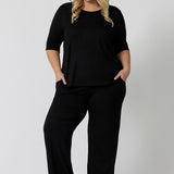 Showing a sleepwear slouchy tee top, a size 18 woman wears a plus size lounge top in black bamboo with straight leg black bamboo lounge pants. A 3/4 top with high neck, this lounge top is breathable and thermo-regulating so it make good pyjamas for night sweats and hot flushes. Shop lounge and sleepwear in sizes 8 to24 online at L&F Australia.