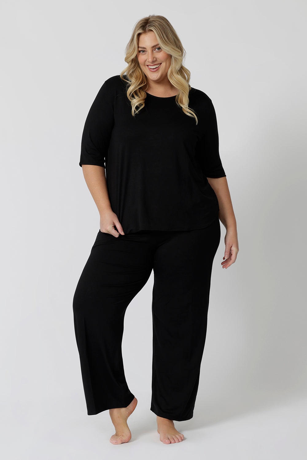 The ultimate outfit for comfortable loungewear, a size 18 woman wears straight wide leg black bamboo lounge pants with a black bamboo slouchy tee top.  Thermo-regulating and breathable this is a great pyjama set for night sweats and hot flushes. Shop plus size lounge and sleepwear online at L&F Australia.