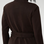 The Sorel Trench Coat is expertly tailored with a modern, sophisticated silhouette that elevates any wardrobe. Size 10 woman wears winter coat crafted from a luxurious winter-weight Modal fabric over long length black pants, black turtle neck, and high heel boots for an elevated workwear look. 