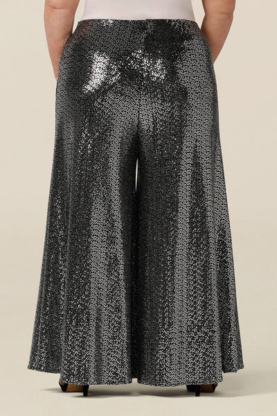 Back view of sparkly sequin pants for cocktail and evening wear. In size 18, these wide leg cocktail wear pants are great plus size sequin pants for dazzling curves! Shop Australia-made wide leg sequin trousers in sizes 8 to 24 at Leina & Fleur.
