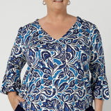 The shirttail hemline provides a polished finish, allowing the top to be worn tucked in or left out for a more relaxed look. Available in sizes 8-24, this top is Australian-made, proudly designed to cater to a range of body types with a focus on both style and comfort.