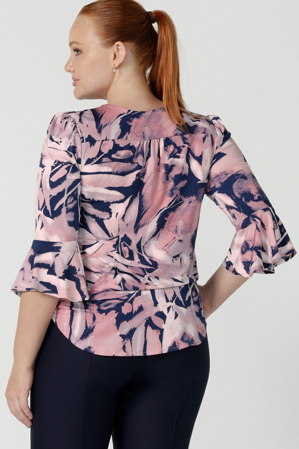 Back view of a size 12 woman wears the Tahlia top in Cantata. Fluted sleeves and a v-neckline. A great V-neckline top with 3/4 sleeves. Soft slinky jersey perfect for comfortable workwear for women size 8 - 24.