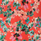 Swatch of floral print on tangerine Italian viscose used by women's clothing brand Leina & Fleur to make summer wrap dresses and cami tops for women.