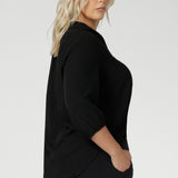 Side view of plus sized woman wears Graphite coloured woven shirt with collar and tailored pleat with navy workwear pants and black heels for an elevated corporate look. Made from sustainable Tencel fabric in Australia for petite and plus size woman sizes 8-24. 