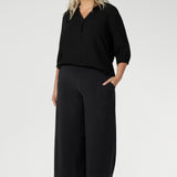 Plus size woman wears Graphite coloured woven shirt with collar and tailored pleat with charcoal workwear pants and black heels for an elevated corporate look. Made from sustainable Tencel fabric in Australia for petite and plus size woman sizes 8-24. 