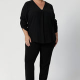 Size 18 model wears v neck blouse. The back neckline is finished with a facing and a neat tailored pleat for subtle detail. Available in sizes 8-24.