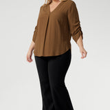 The elegant V-neckline features a tailored tuck at the centre front, while the back is finished with a subtle pleat for a touch of structure and flow. With beautifully ruched ¾ sleeves. Worn by size 18 woman worn with black bootleg pants. 