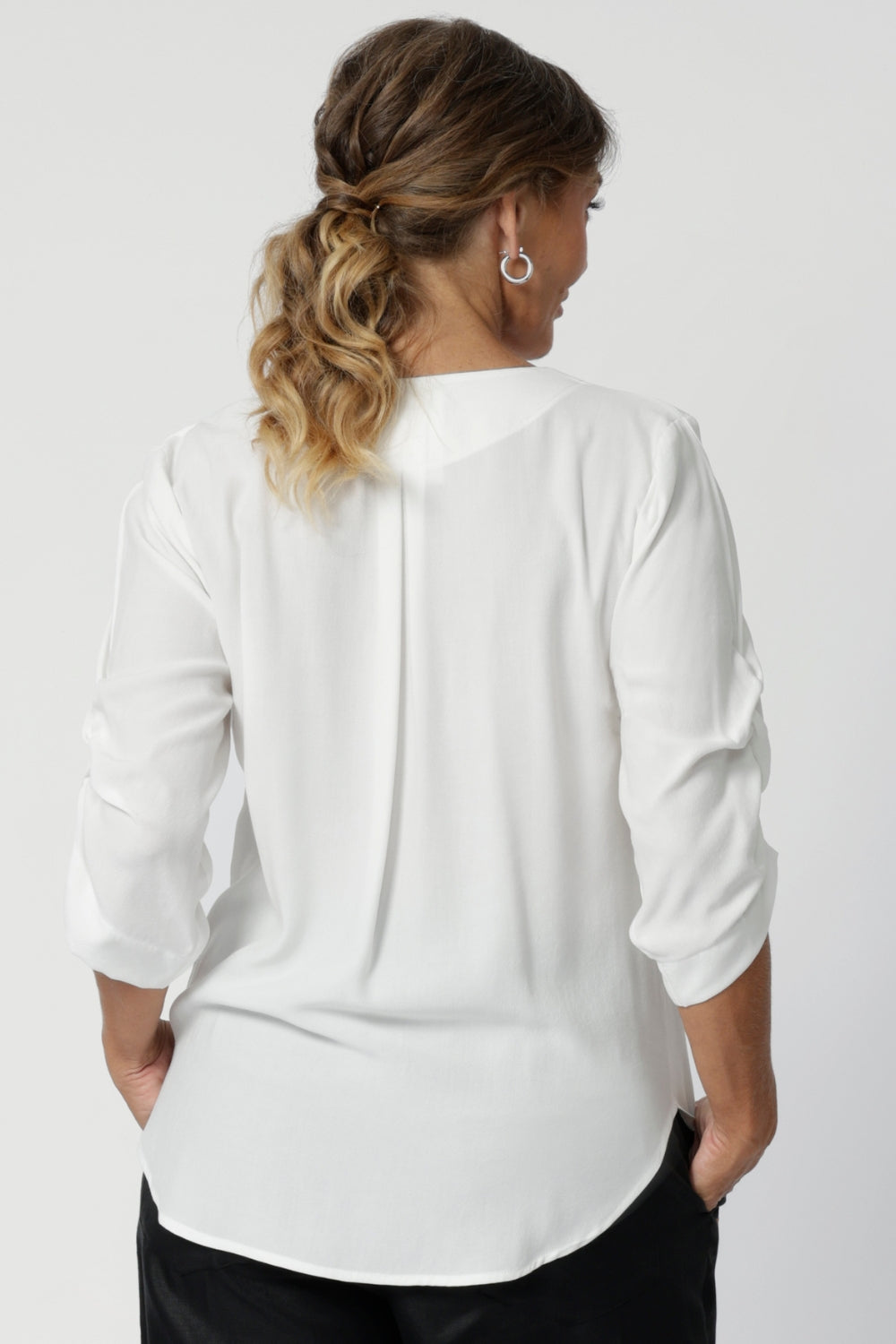 Made from a soft, breathable Tencel Viscose fabric, it boasts a sand-washed texture that feels luxurious against the skin and drapes beautifully, offering a flattering silhouette. Over 40's woman wears workwear top in size 12.