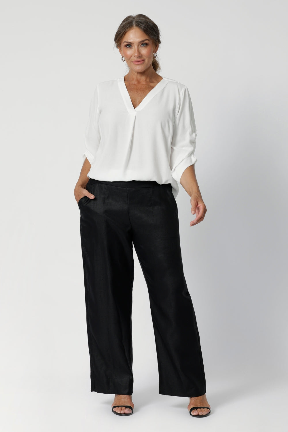 Its 3/4-length sleeves are designed with ruching, a thoughtful design element that gathers the fabric towards the center front of the arm, giving the shirt an elegant, polished look. The shirttail hemline adds a bit of fluidity and movement, while still maintaining a clean, professional finish.