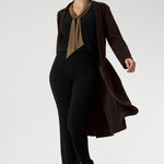 Proudly Australian made, the Thom Top is available in an inclusive size range from 8 to 24, delivering effortless sophistication and comfort for both workwear and special occasions. Over 30's woman wears her Thom Top with black work pants and brown coat.