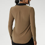 Full-length sleeves with gentle gathers at the shoulders add a touch of femininity, while the shoulder yoke and tailored tuck at the back create subtle shape without feeling structured. Finished with a shirttail hemline, it’s a top that layers easily under suiting and transitions seamlessly from desk to dinner. 