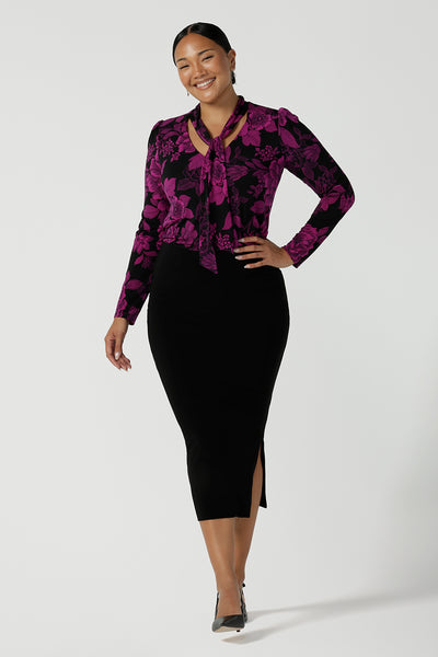 A size 10 model wears the Thom top in Fuchsia Flora is sophisticated and so versatile. Tie the neck-ties to the front for a day in the office or leave the ties open for your next event.
