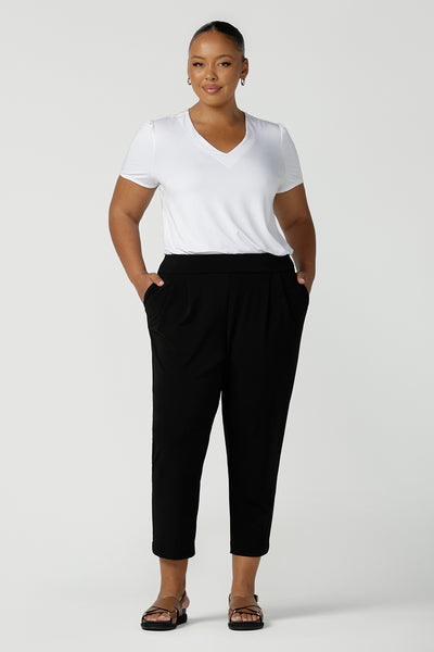Great plus size pants for travel, these tapered leg, black jersey pants are super comfortable to wear! Worn with a V-neck short sleeve top in white bamboo jersey, these dropped crotch pull-on pants are made in Australia. Shop women's travel pants online in petite, mid size and plus sizes at Leina & Fleur.