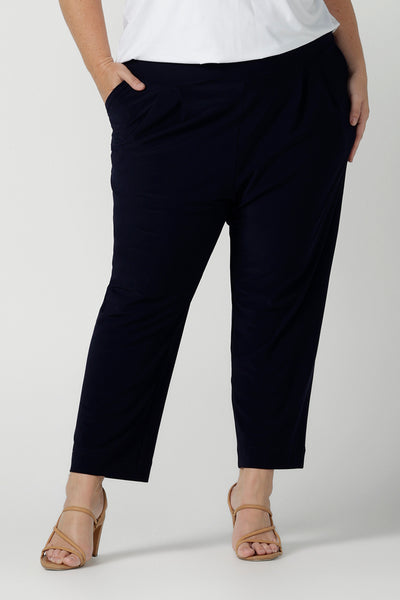 Close up of a size 18 curvy woman wears the Tobie pant in Navy. A comfortable navy work pant with pleat front and pocket detail. Great work pants in soft Jersey. Great for petite to plus size. Made in Australia for women size 8 - 24.