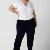 A size 18 curvy woman wears the Tobie pant in Navy. A comfortable navy work pant with pleat front and pocket detail. Great work pants in soft Jersey. Great for petite to plus size. Made in Australia for women size 8 - 24.