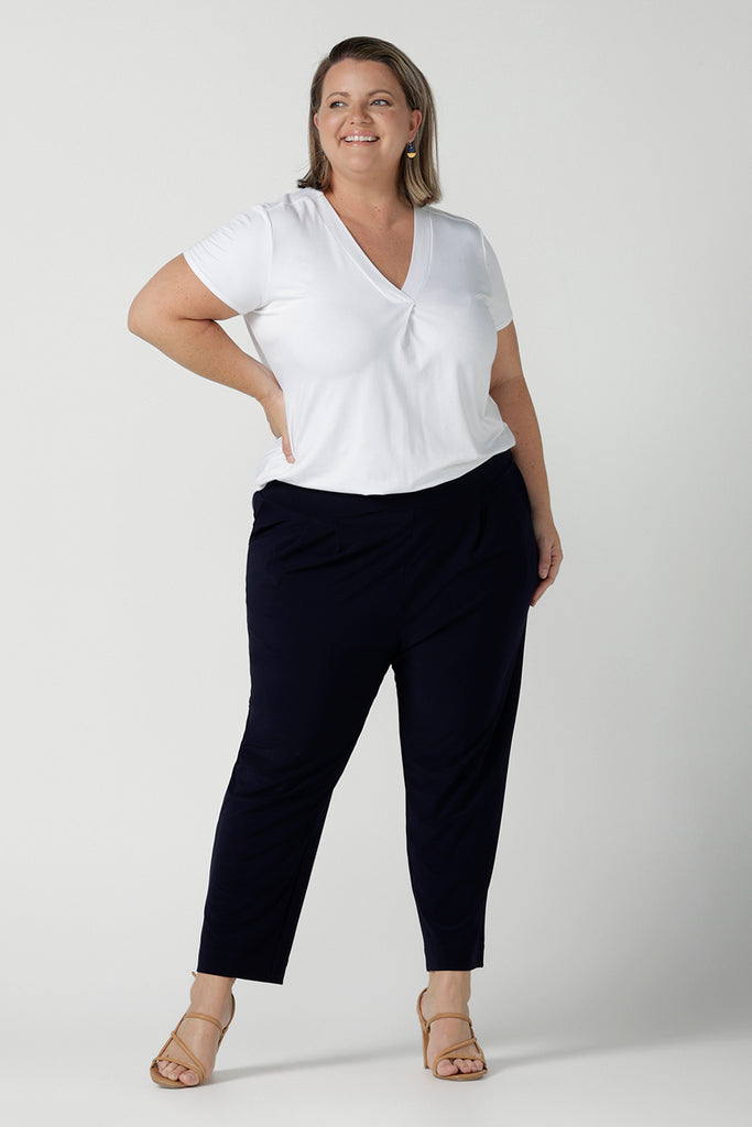 A size 18 curvy woman wears the Tobie pant in Navy. A comfortable navy work pant with pleat front and pocket detail. Great work pants in soft Jersey. Great for petite to plus size. Made in Australia for women size 8 - 24.