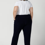 Back view of a size 18 curvy woman wears the Tobie pant in Navy. A comfortable navy work pant with pleat front and pocket detail. Great work pants in soft Jersey. Great for petite to plus size. Made in Australia for women size 8 - 24.