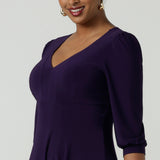 Close up of a woman wearing a size 10 Amethyst purple Tracey dress in comfortable jersey. A great work wear style that is easy care with an empire line and 3/4 sleeves. Below knee length with a v-neckline. Petite to plus size size 8-24.