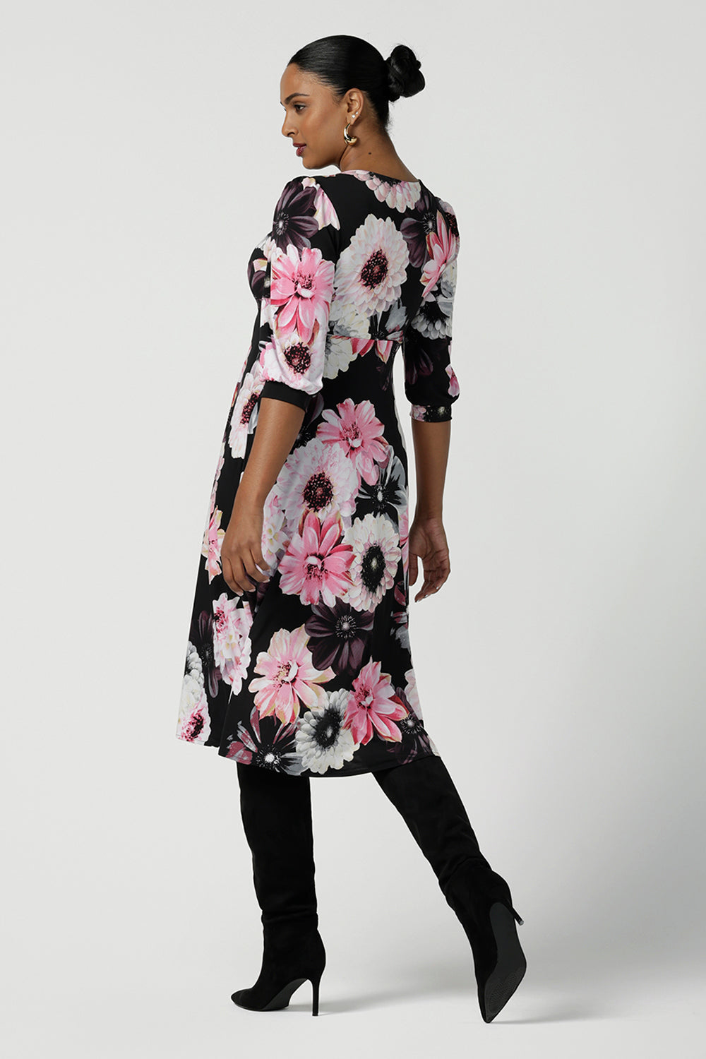 Back view of a size 10 woman wears the Tracey Dress in Night bloom. A Empire Line Dress with a floral print on a black base. Comfortable jersey design. Made in Australia for women size 8-24. Petite to plus size women.