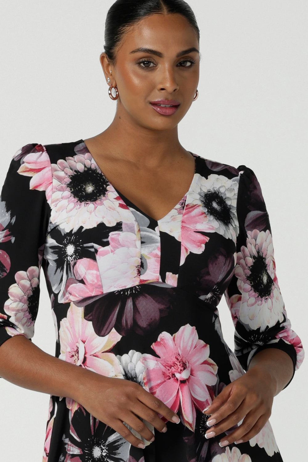 Close up of a size 10 woman wears the Tracey Dress in Night bloom. A Empire Line Dress with a floral print on a black base. Comfortable jersey design. Made in Australia for women size 8-24. Petite to plus size women.